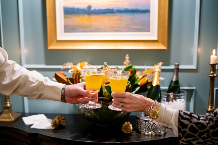 Couples hands toasting with orange cocktails.
