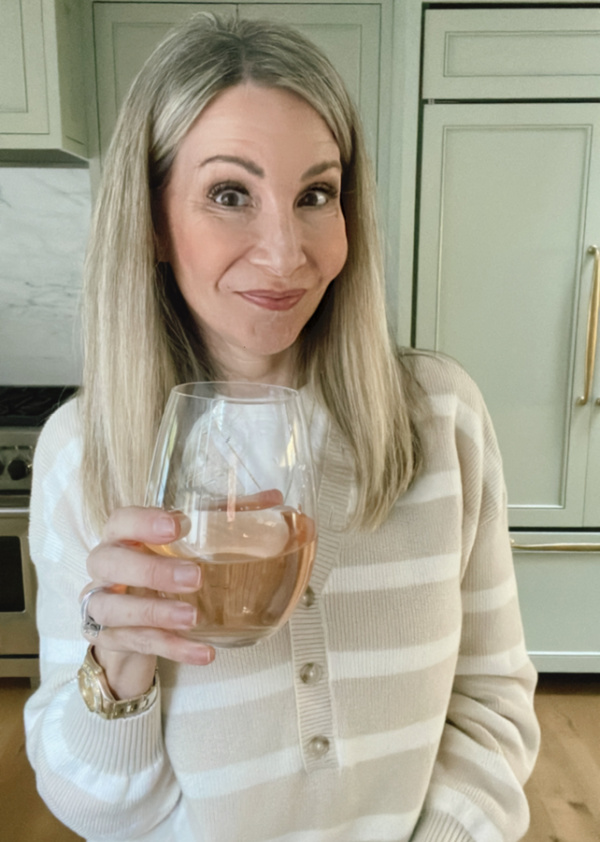Woman holding glass of rose wine.