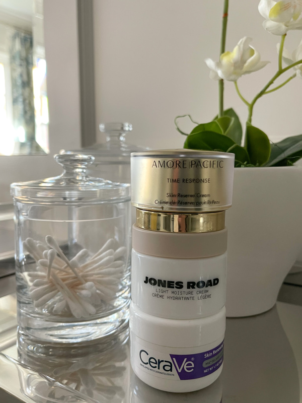 Three skincare creams stacked on a vanity tray.