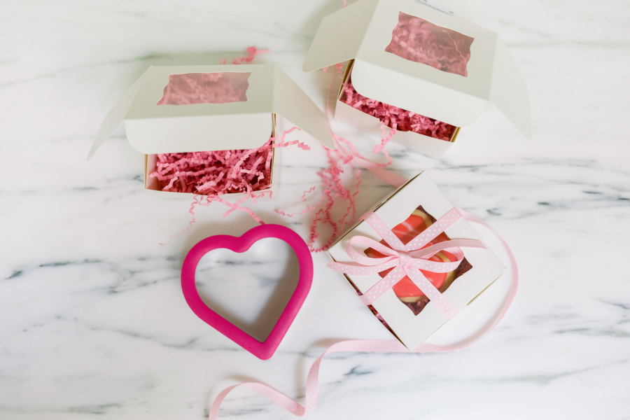 Heart shaped cookie cutter and boxes of cookies.
