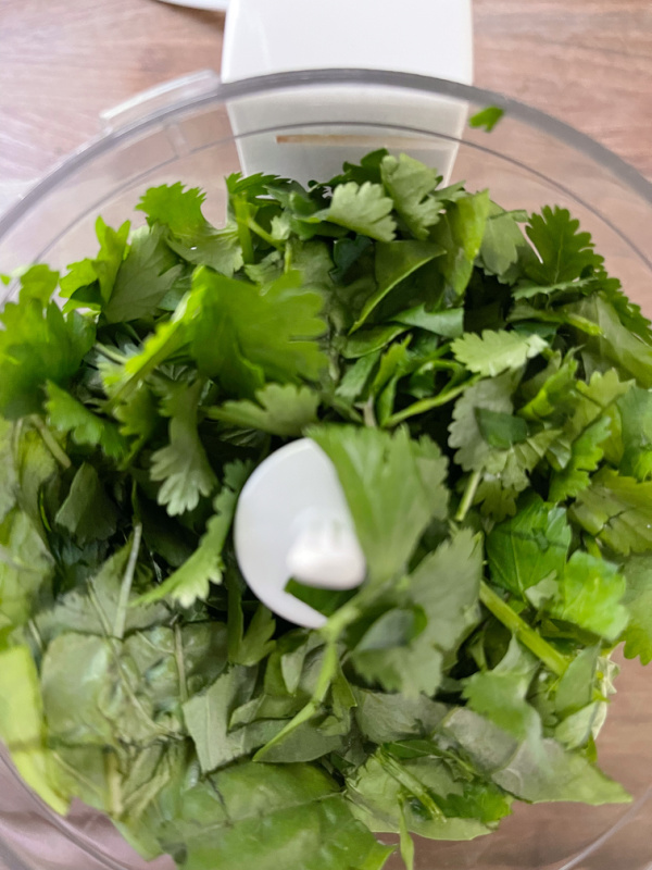 Salsa verde herbs in a mini-processor.