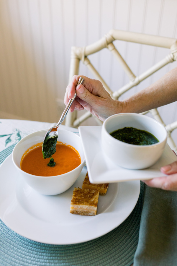 Adding salsa verde to tomato soup.