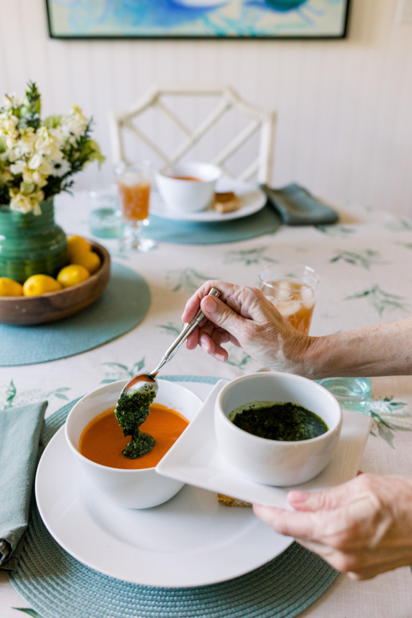 Adding salsa verde to tomato soup.