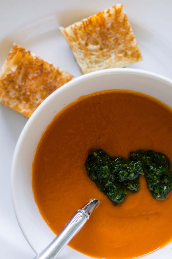 Tomato soup topped with salsa verde and grilled cheese squares.