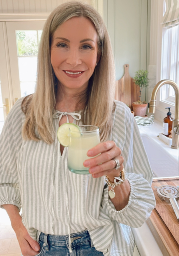 woman holding yuzu mezcal margarita.