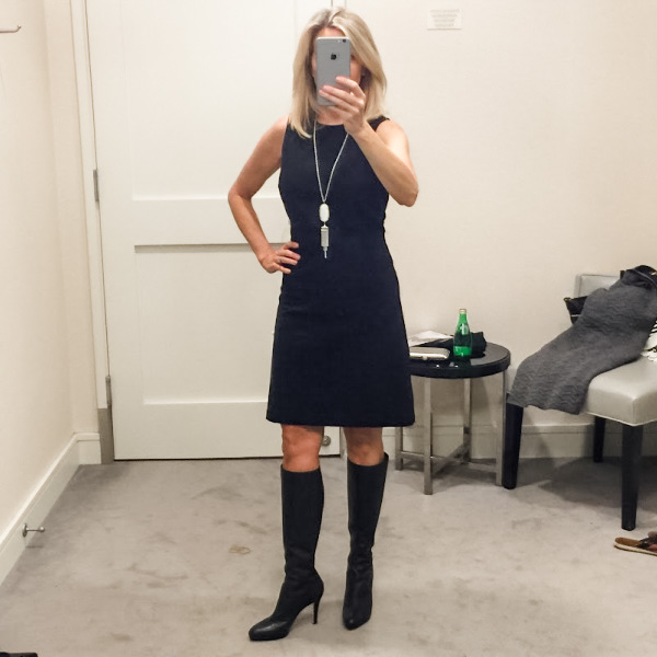 Woman wearing little black dress in dressing room.