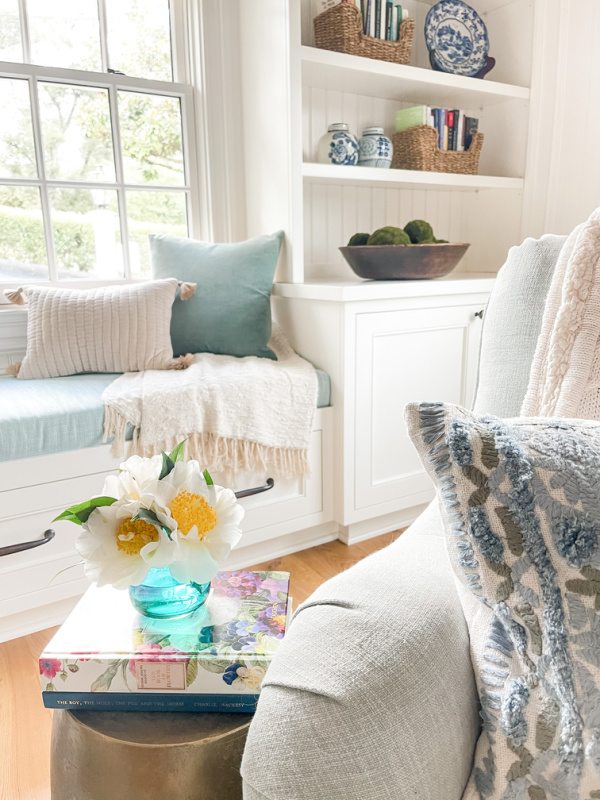 Vase of camellias on small table.