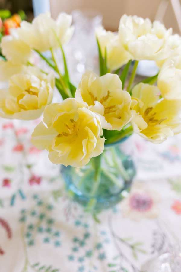 White tulips in vase on table.