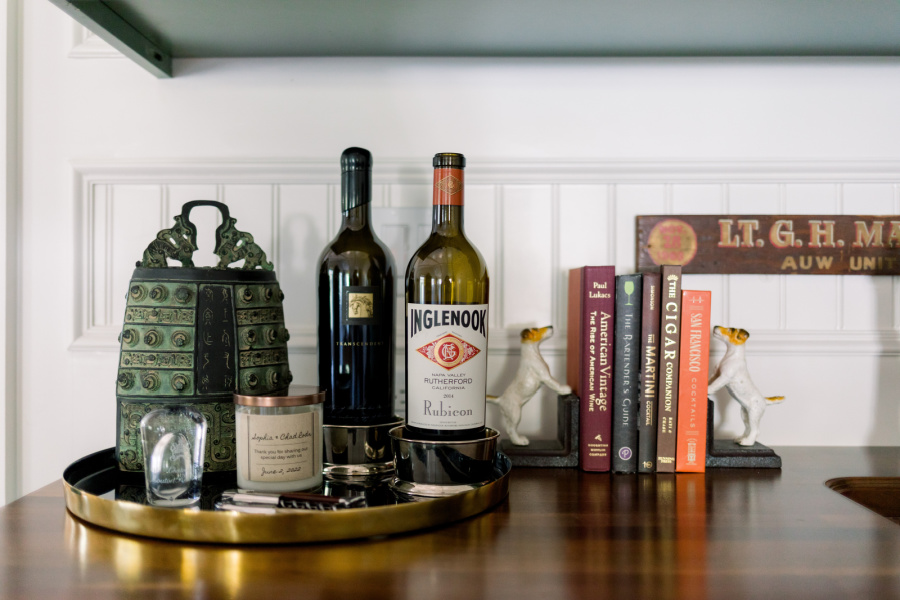 Wet bar cabinet with tray of wine and cocktail books.