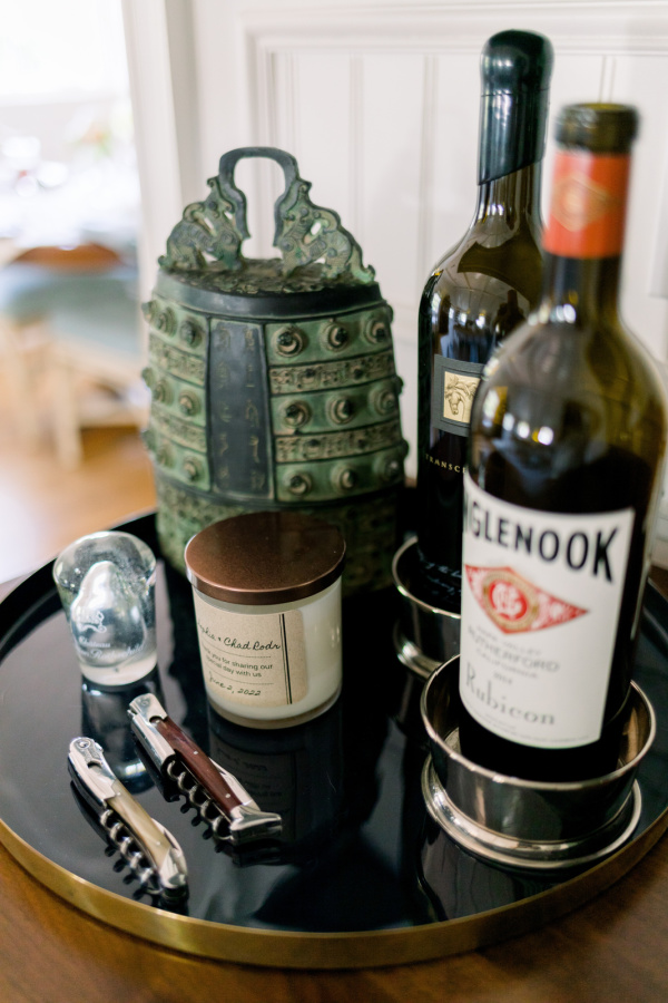 Tray of wine and openers and candle.