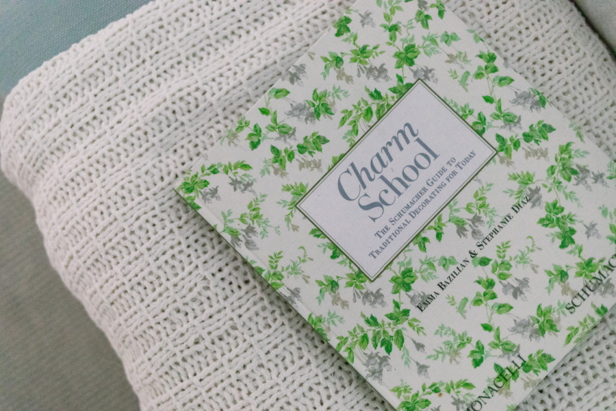 Charm School book on end of bed bench.