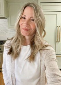 Woman taking selfie in green kitchen.