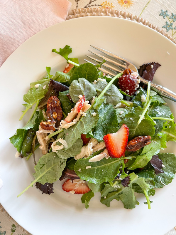 Spring salad on a plate with fork resting.