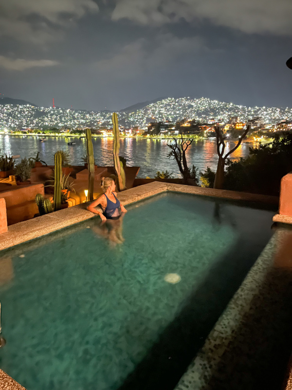 Woman in pool at night overlooking Zihautaneno.