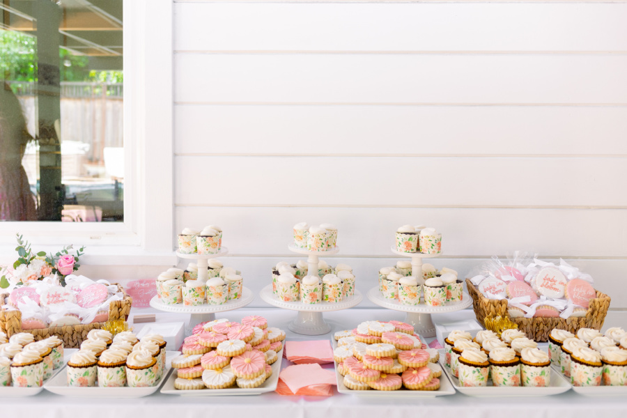 Baby girl shower dessert buffet with cookies and cupcakes.