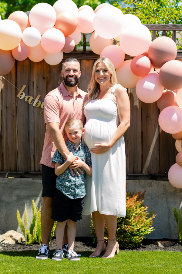 Pregnant couple with their young son at baby shower.