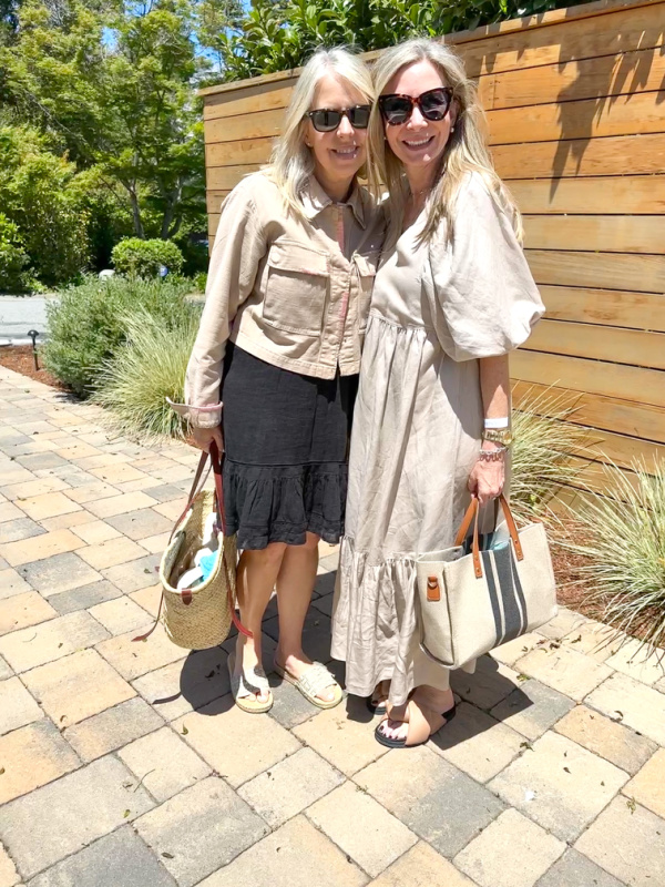 Two woman standing in front of garden fence.
