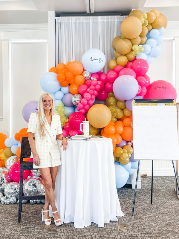 Kym Showers Life Coach standing in front of her retreat backdrop.