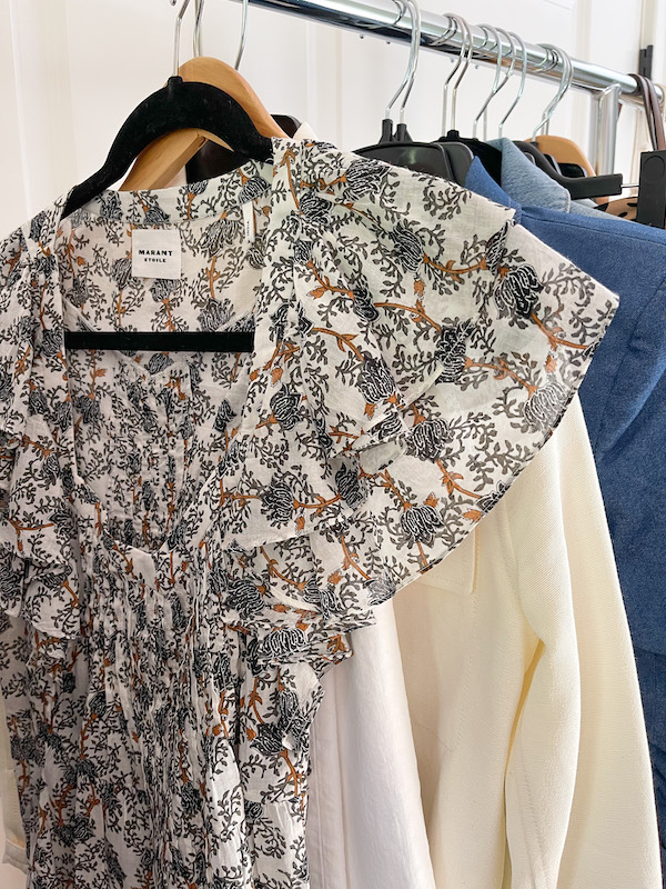 Ruffle sleeve blouse and white denim on hanger.