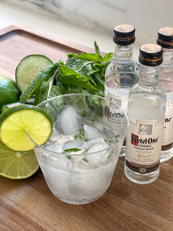Cucumber Mint Lime Presse in a glass with three mini-bottles of Vodka.