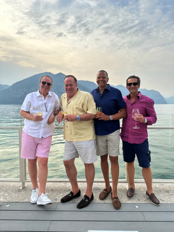 Four men standing on pool deck in Italy.