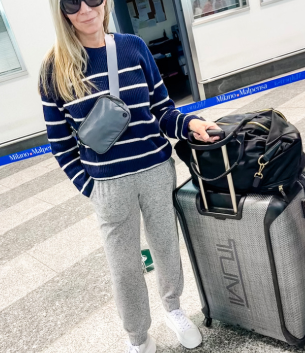 Woman standing next to luggage in airport.