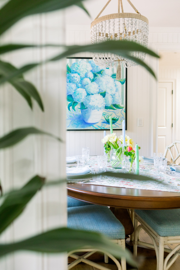 Dining room table with floral table throw and candles.