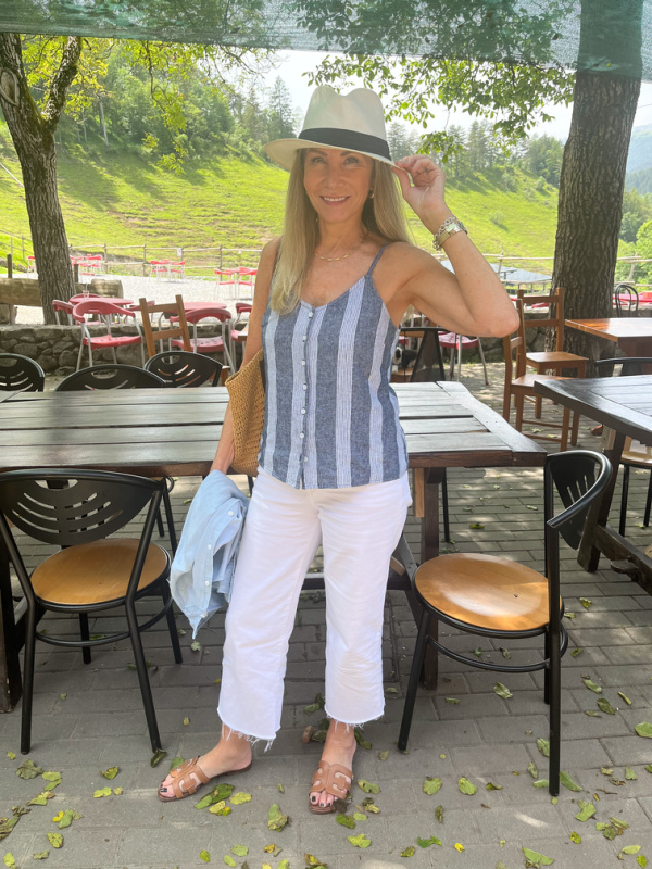 Woman wearing striped top and hat at Italian restaurant.