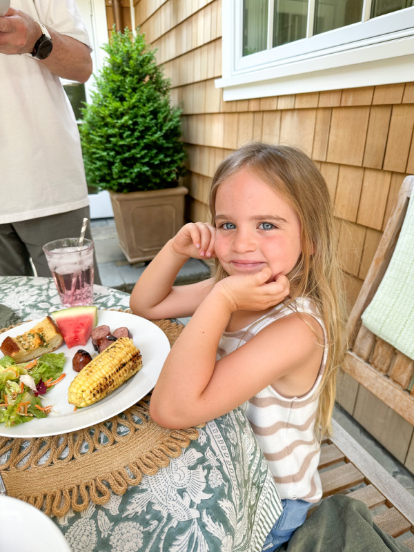 Little girl sitting at table with her food.