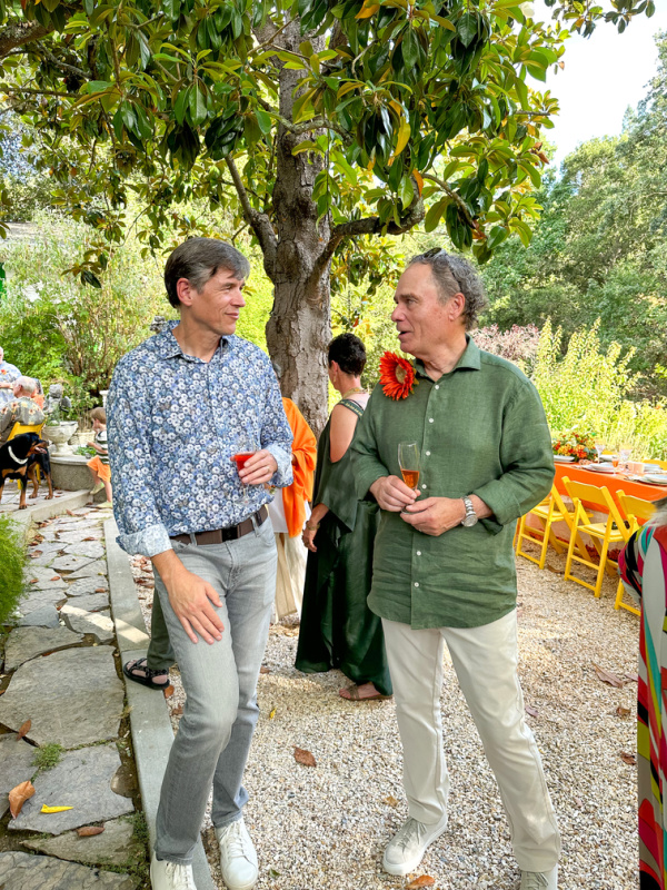 Two men chatting at garden party.