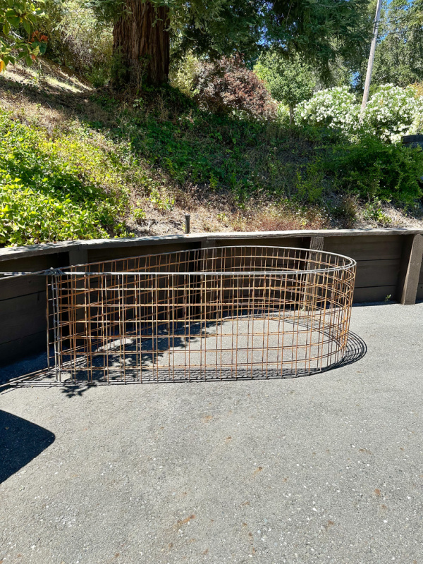 Wire garden arched trellis laying in driveway.