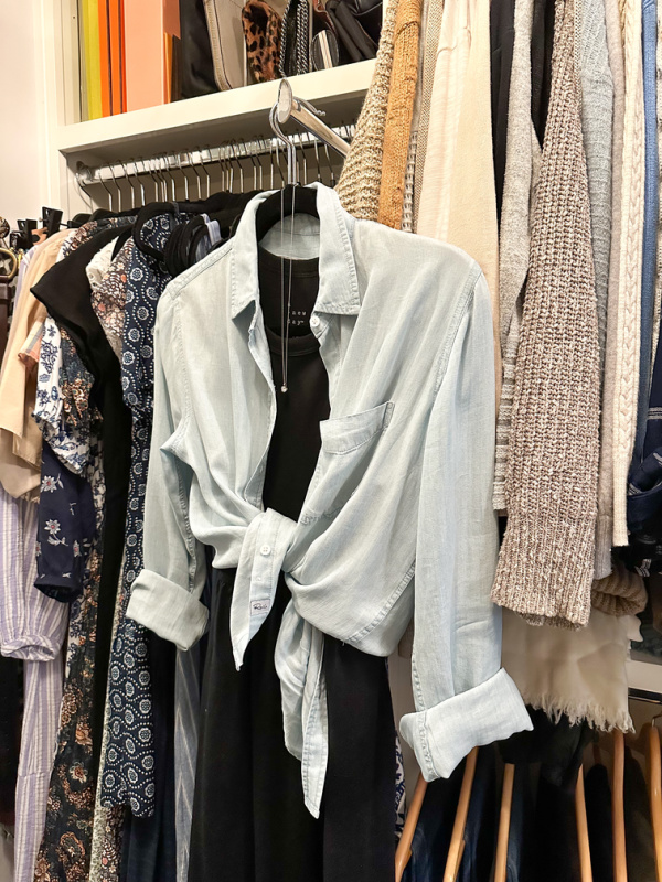 Black dress and blue shirt on valet pull in closet.