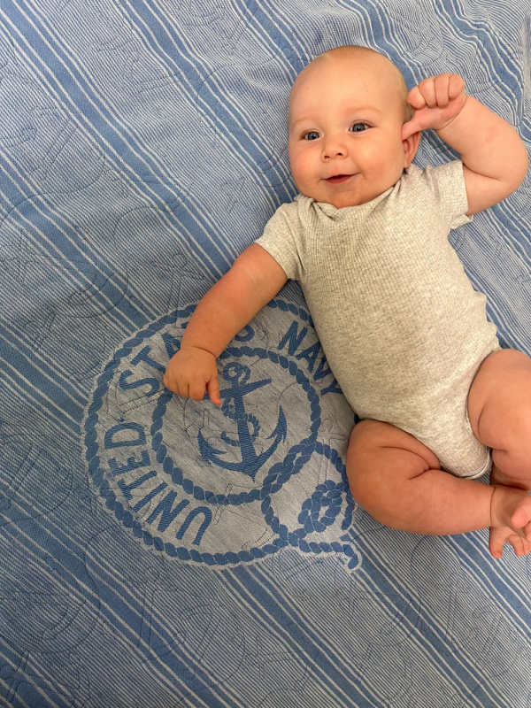 Baby laying on US Navy quilt.