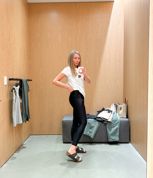 Woman in dressing room trying on yoga pants.