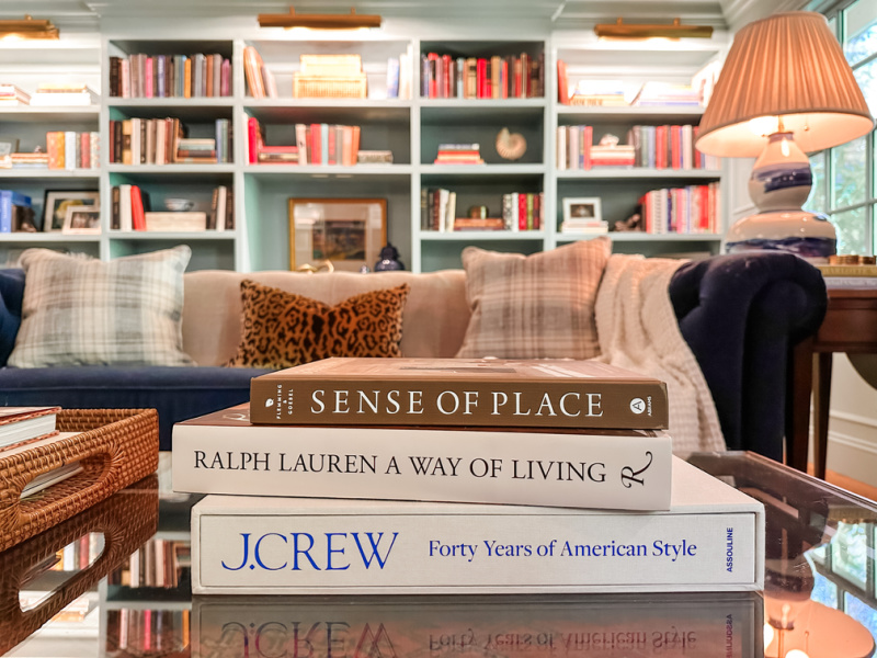 Books stacked on coffee table in home library.