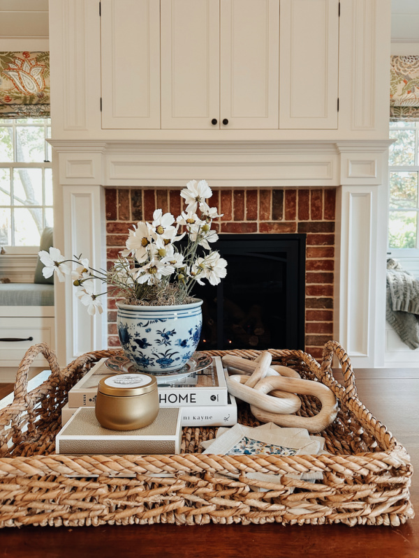 Coffee table tray with autumn candle in front of fire.