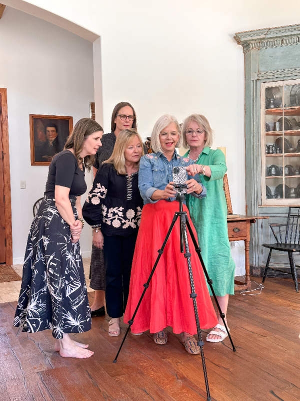 Woman showing 4 others how to use tripod.
