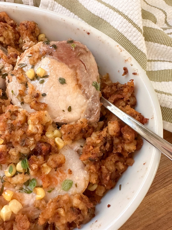 Dish of baked pork chops and stuffing ready to serve.