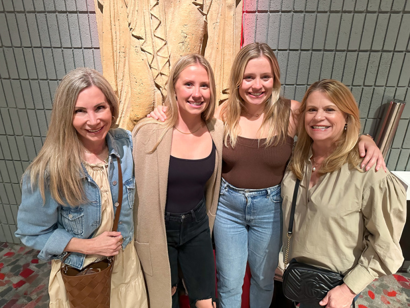 four women standing in the lobby of the Palace of Fine Arts Theater. 