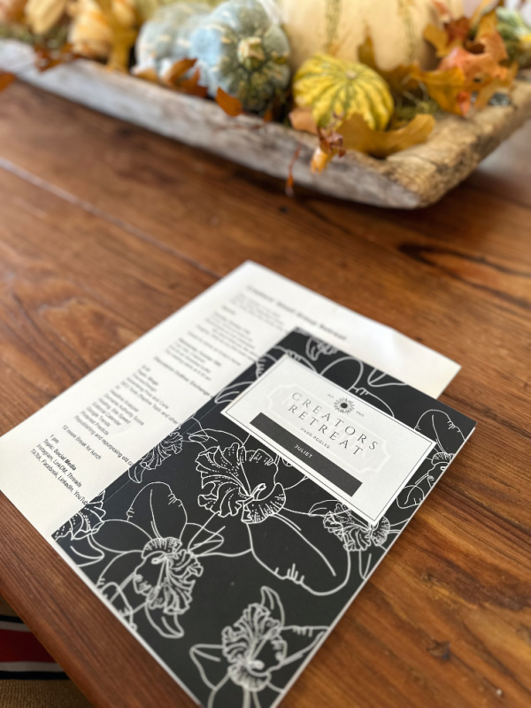 Meeting agenda and notebook on table next to dough bowl of pumpkins.