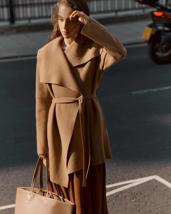 Model wearing Cuyana camel sweater coat.