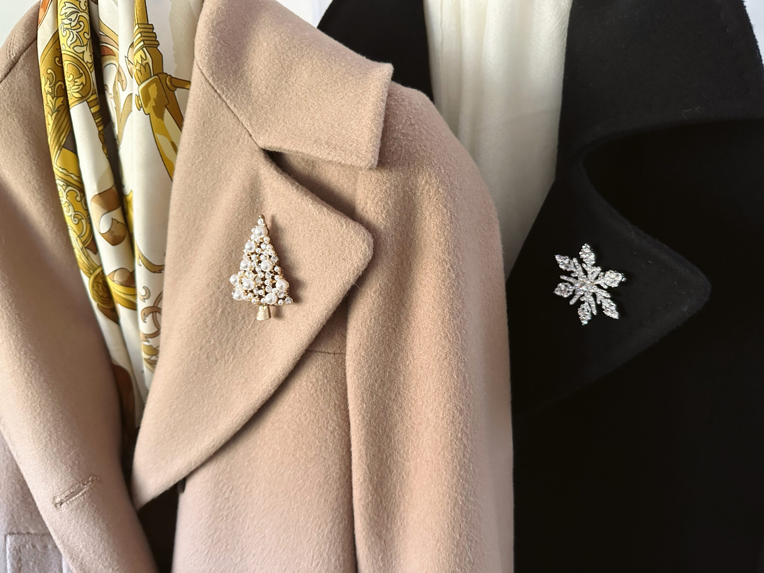 Holiday brooches pinned to two winter coats.