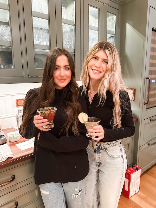 Two women with holiday drinks in their hands.