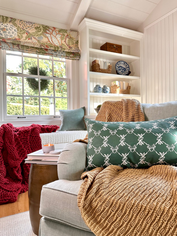 Family room swivel chair with brown throw blanket and holiday pillow.