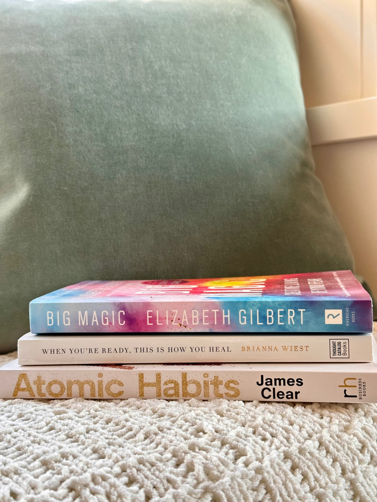Three books sitting on window bench.