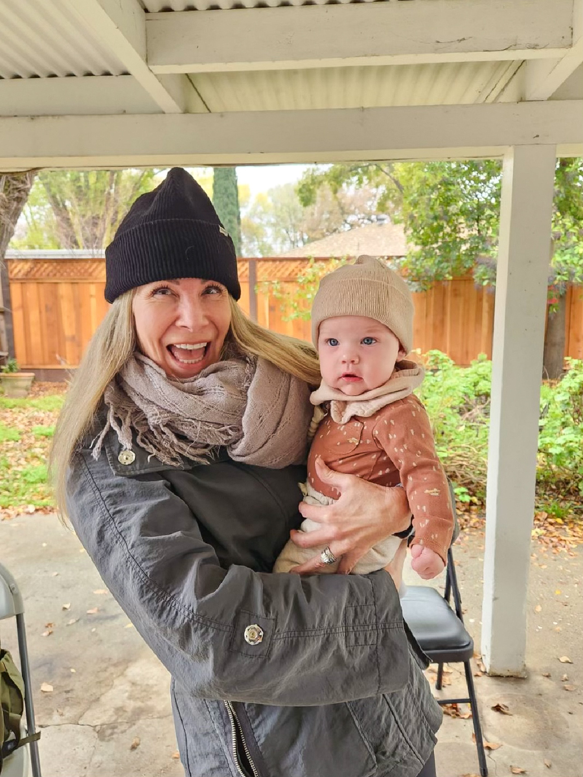 Woman holding baby outside in the winter.