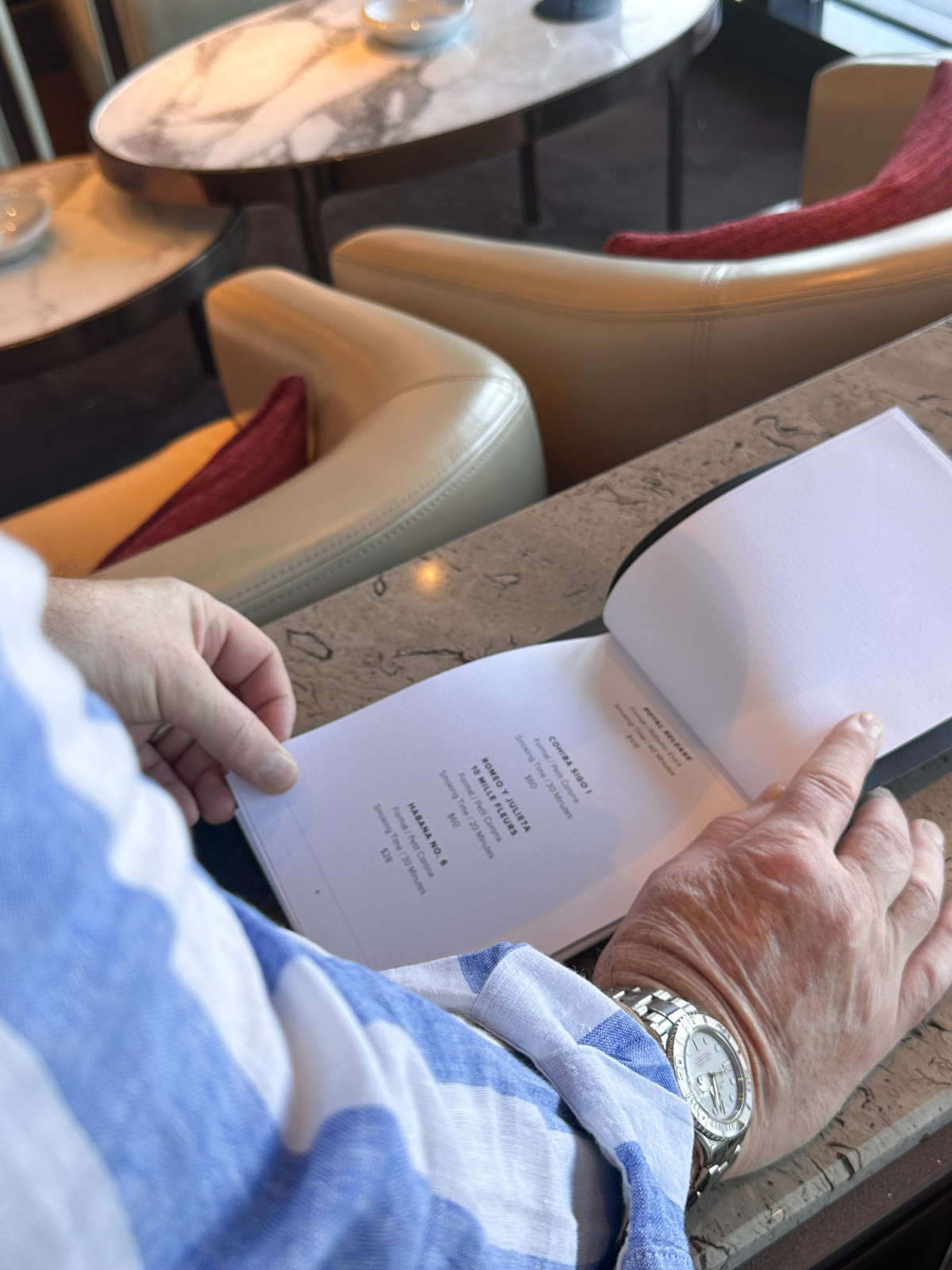 Man reading cigar menu on Evrima yacht.