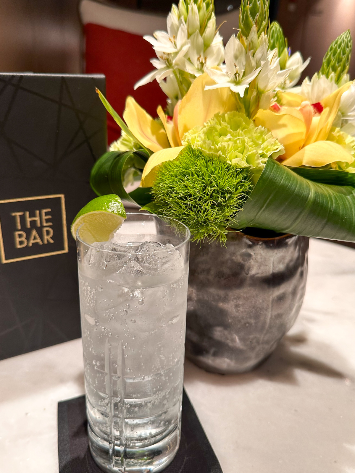 Drink, flowers, menu at The Bar on Evrima yacht.