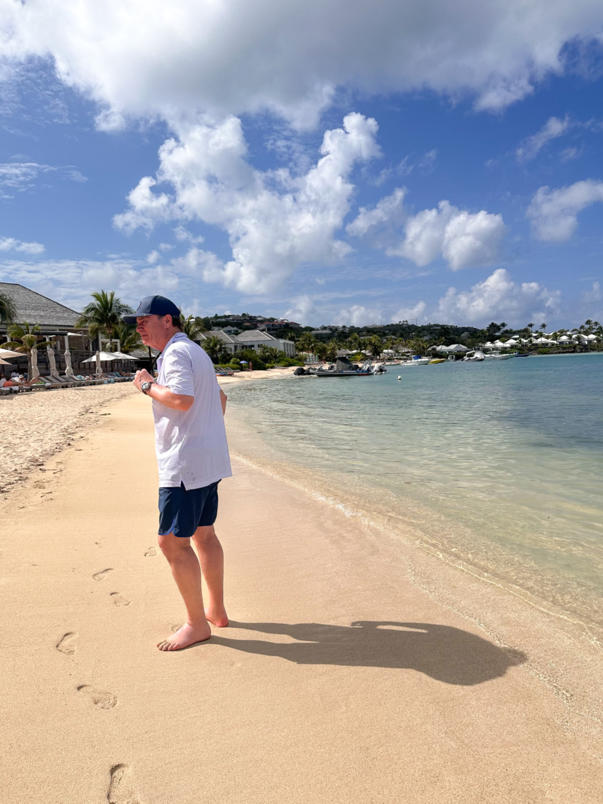 Man walking on beach at St. Barthelemy Hotel.