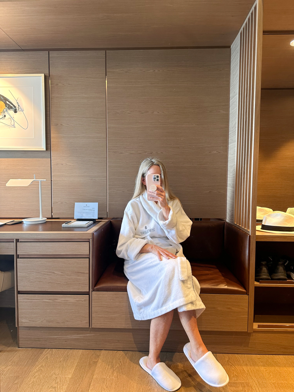 Woman wearing bathrobe taking mirror selfie.